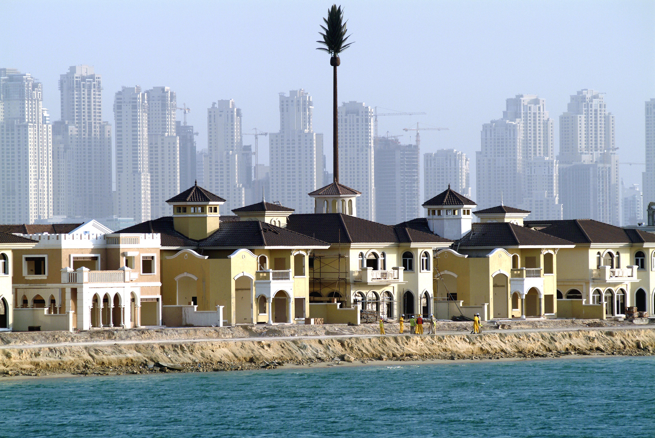 Dubai, United Arab Emirates. Construction of villa's on the Palm Jumeirah, reclaimed land in the shape of a palm tree.In background Jumeirah skyline on the mainland. Photo (c) Paul van Riel