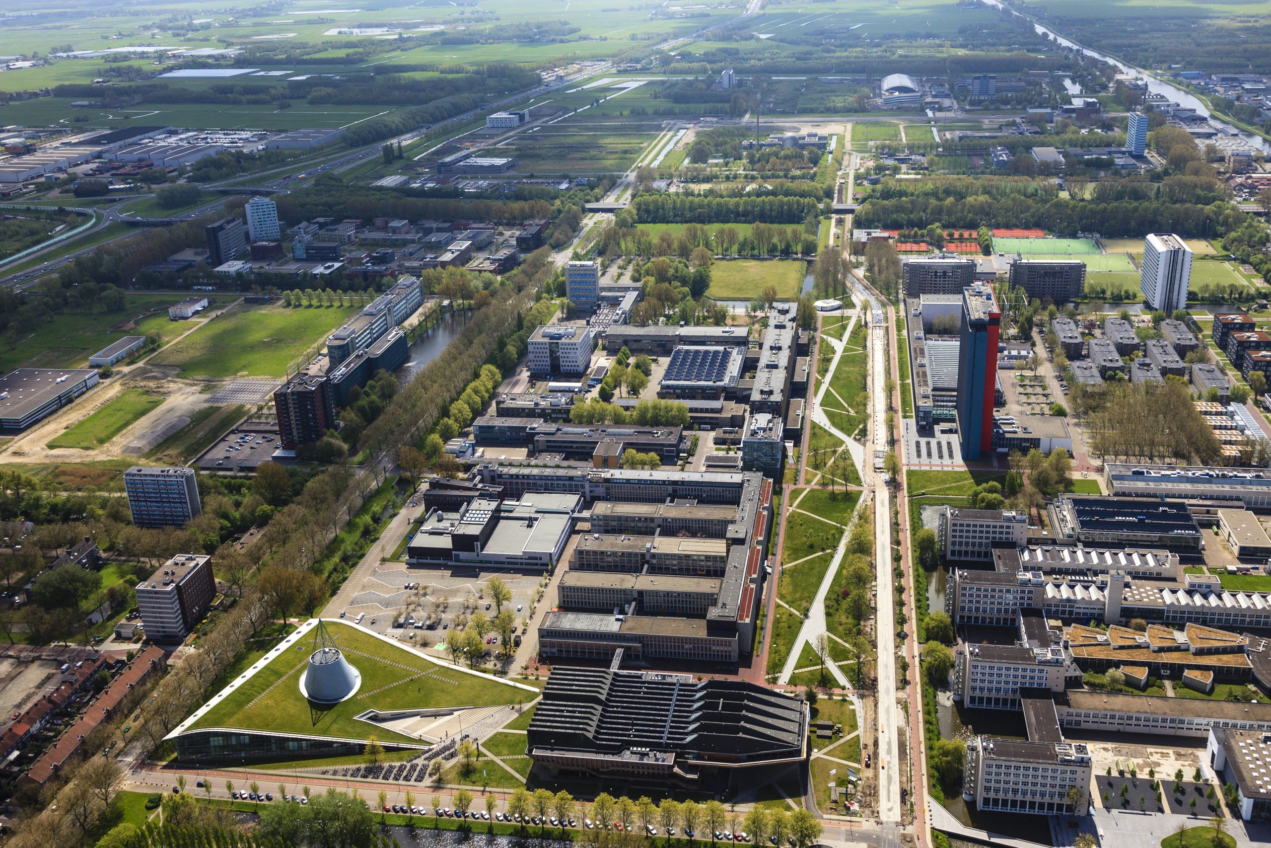 Nederland, Zuid-Holland, Delft, 09-05-2013; overzicht Campus TU Delft met in de voorgrond de Delft TU bibliotheek (met grasdak, ontwerp Mecanoo) en de Aula annex Conferentie Centrum. Het gebouw met logo en rode gevel is van Elektrotechniek, Wiskunde en Informatica (EWI).
Overview of the Campus of the Delft University of Technology. In the foreground Library (Mecanoo  architects) and auditorium. The high-rise red-striped building is the faculty of Electrical Engineering, Mathematics and Computer Sciences (EEMCS).
luchtfoto (toeslag op standard tarieven)
aerial photo (additional fee required)
copyright foto/photo Siebe Swart